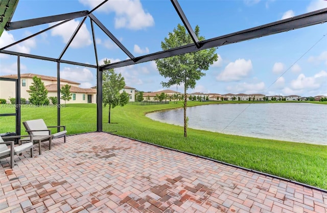 view of patio featuring glass enclosure and a water view