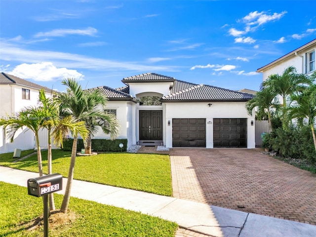 mediterranean / spanish home featuring a garage and a front lawn