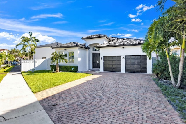 mediterranean / spanish home featuring a front yard and a garage