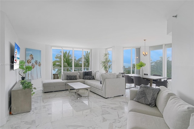 living room with a healthy amount of sunlight, an inviting chandelier, and floor to ceiling windows