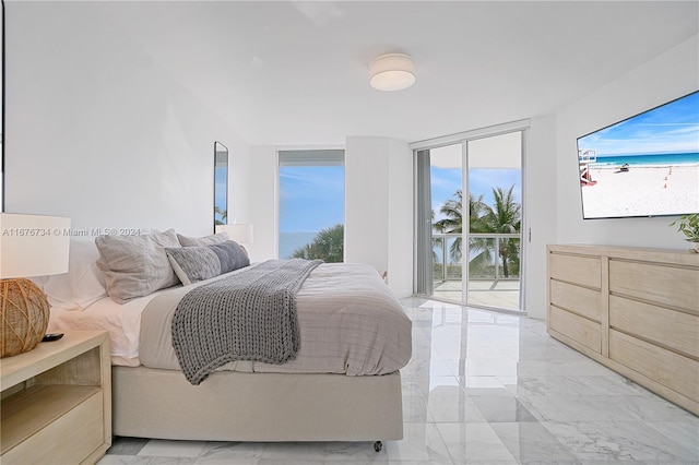 bedroom with access to exterior, a wall of windows, and multiple windows