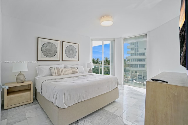 bedroom featuring expansive windows and access to exterior