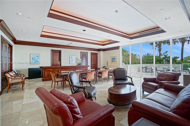 tiled living room featuring ornamental molding, a tray ceiling, and plenty of natural light