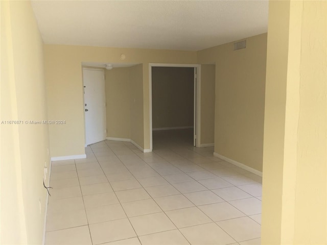 unfurnished room featuring light tile patterned floors, baseboards, and visible vents
