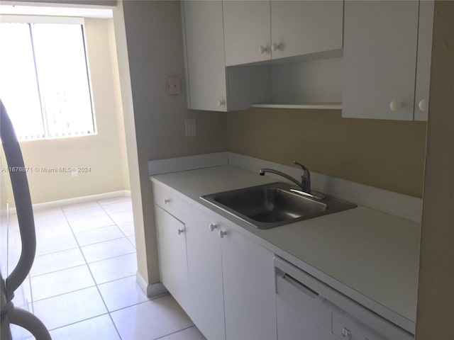 kitchen featuring a sink, light tile patterned flooring, light countertops, and dishwasher