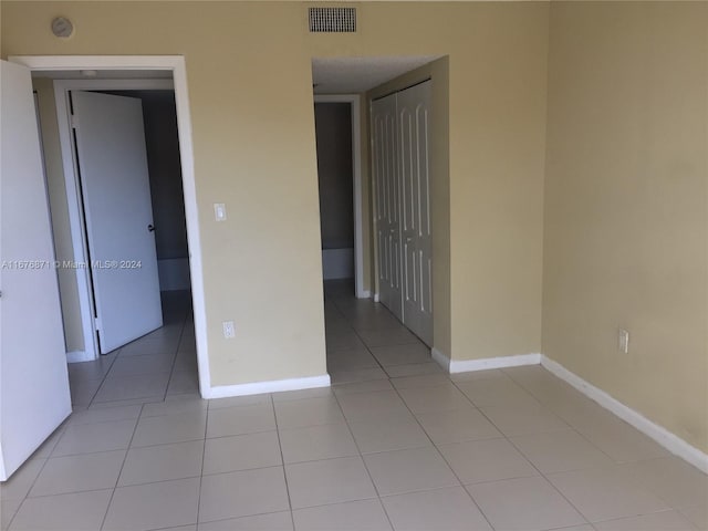 unfurnished room featuring light tile patterned flooring, baseboards, and visible vents