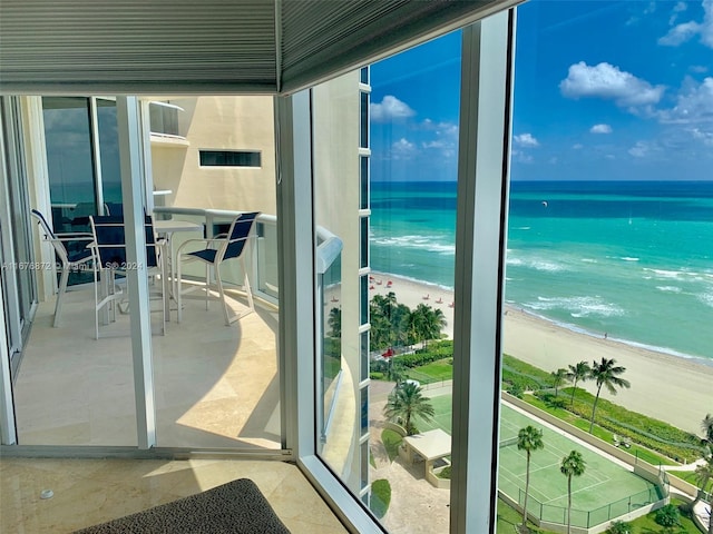 balcony featuring a water view and a view of the beach