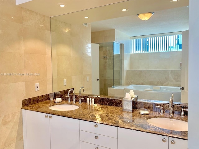 bathroom with vanity, tile walls, and plus walk in shower