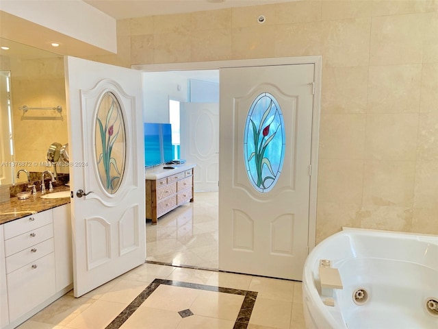 tiled foyer entrance with sink and tile walls