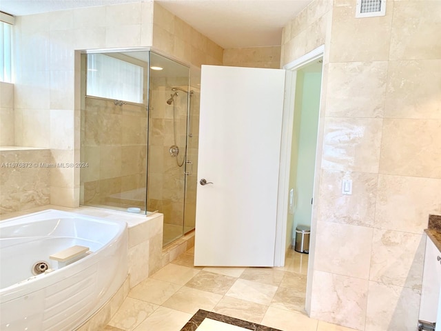 bathroom featuring vanity, tile walls, and shower with separate bathtub