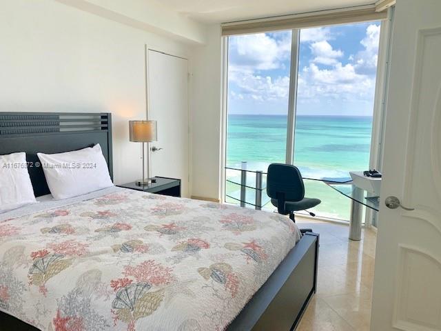 bedroom featuring multiple windows and a water view