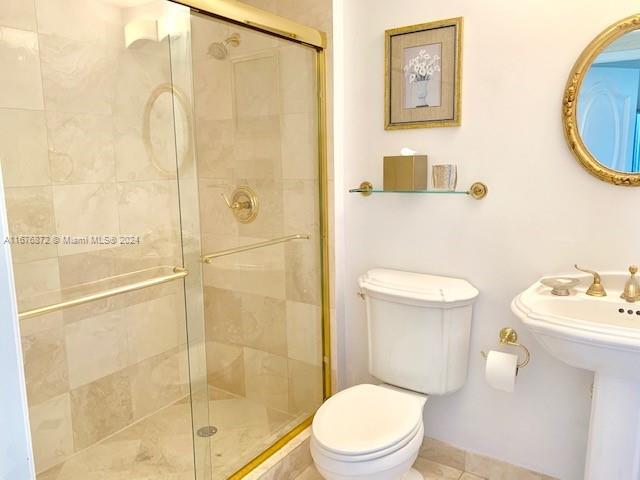 bathroom with tile patterned flooring, toilet, and walk in shower