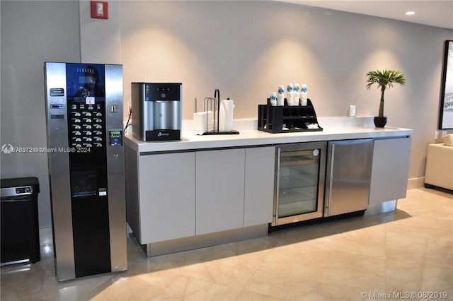 kitchen featuring wine cooler and white cabinets