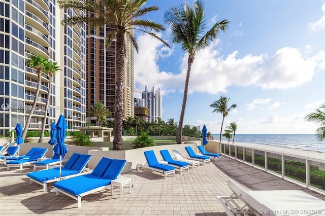 view of swimming pool with a water view and a beach view