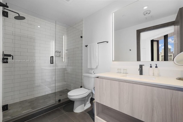 bathroom with vanity, toilet, a shower with shower door, and tile patterned flooring