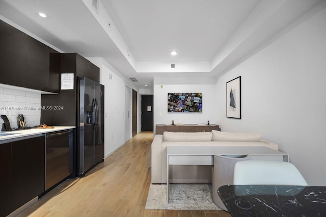 living room featuring recessed lighting, a raised ceiling, light wood-style flooring, and visible vents