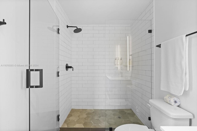 full bathroom featuring a shower stall and toilet