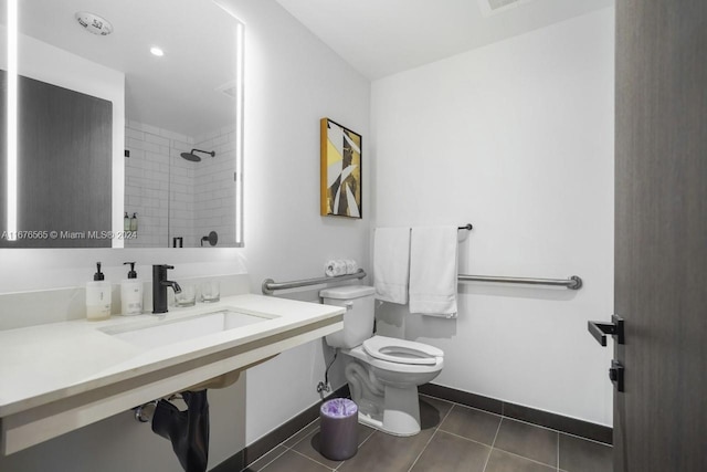 bathroom featuring a tile shower, toilet, and tile patterned floors