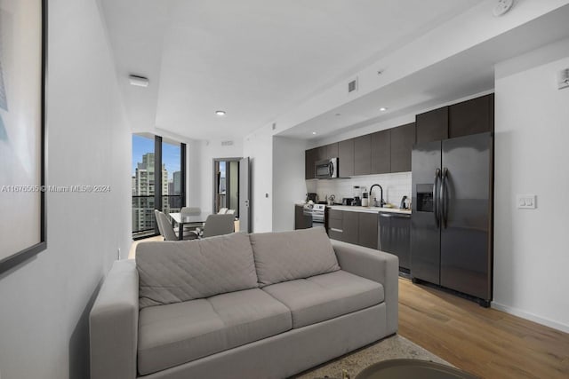 living room with baseboards, light wood-style floors, visible vents, and recessed lighting