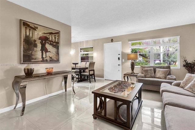 living room with a textured ceiling and tile patterned flooring