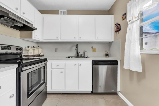 kitchen with sink, white cabinetry, stainless steel appliances, and light tile patterned floors