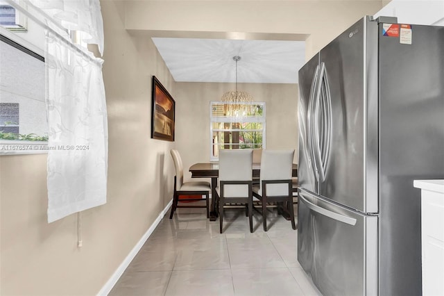 kitchen featuring a chandelier, hanging light fixtures, and stainless steel refrigerator