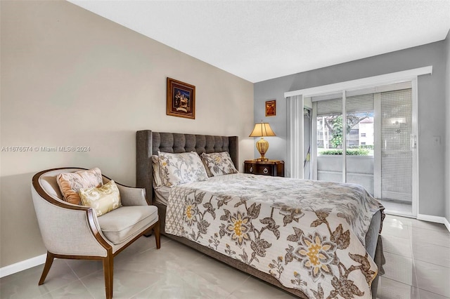 bedroom featuring a textured ceiling and access to exterior