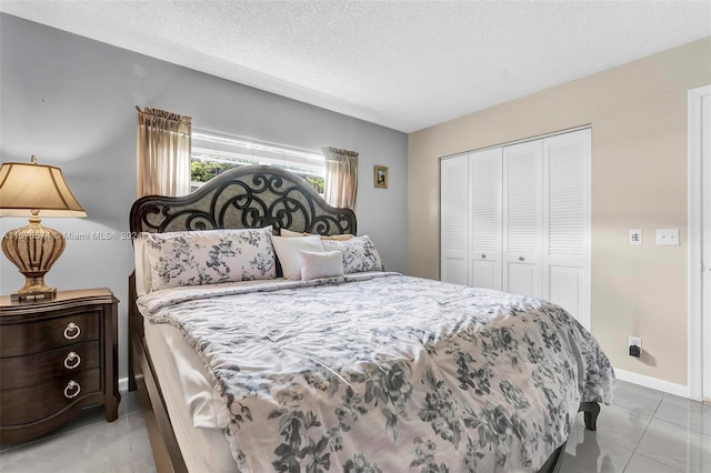 tiled bedroom featuring a closet and a textured ceiling