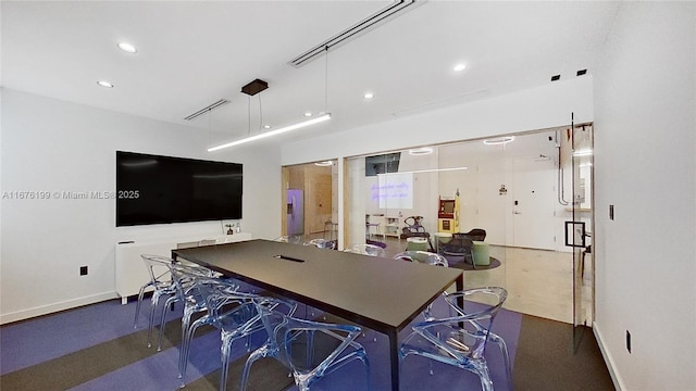 kitchen with a breakfast bar, white cabinets, and pendant lighting