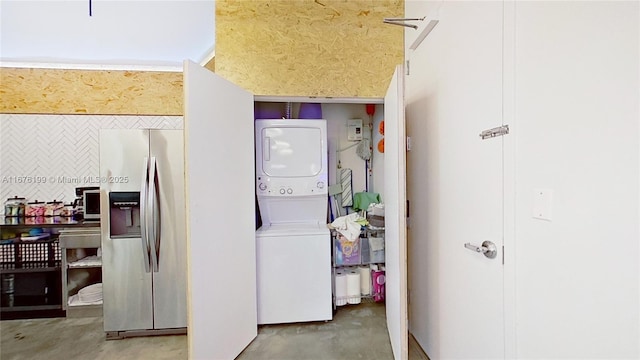 clothes washing area featuring stacked washer / dryer