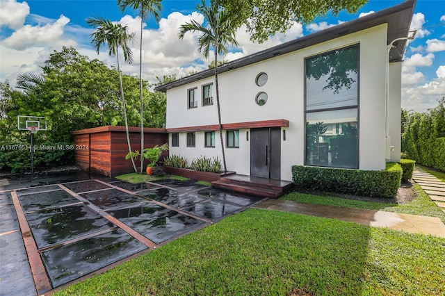 rear view of property with a lawn