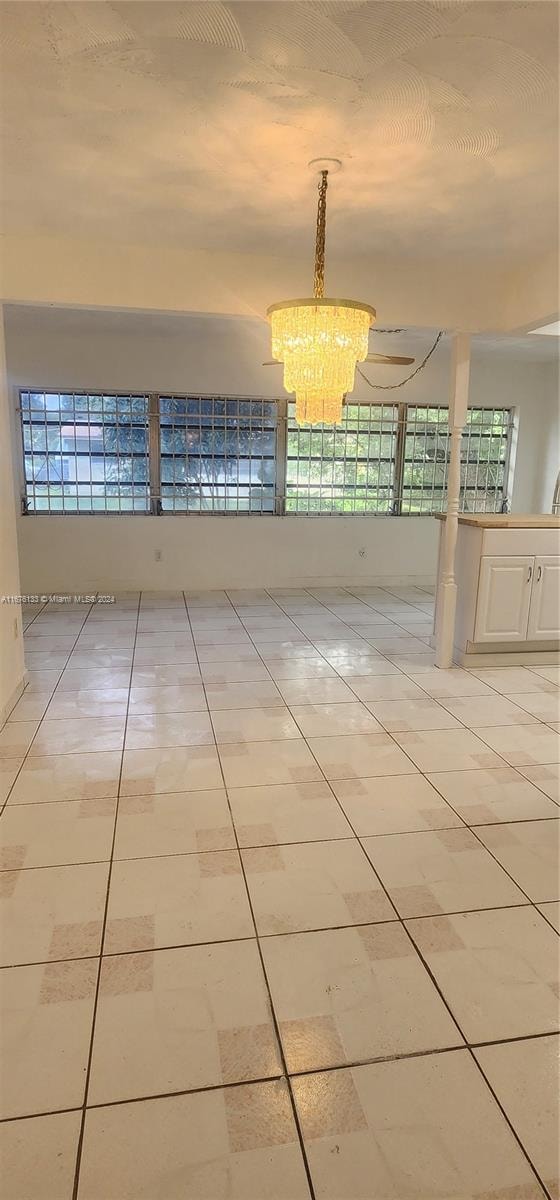 unfurnished room with a notable chandelier and a wealth of natural light