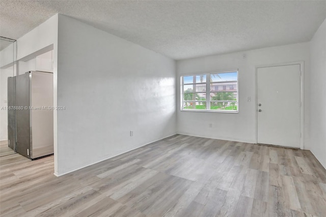 empty room featuring light hardwood / wood-style floors and a textured ceiling