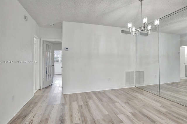 121 NE 204th St Unit 9, Miami Gardens, FL 33179 - unfurnished dining area with a textured ceiling, wood finished floors, a chandelier, and baseboards