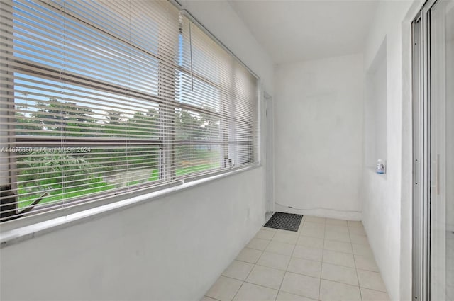 corridor featuring light tile patterned flooring and plenty of natural light
