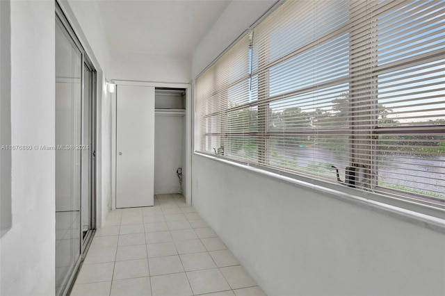hallway with a healthy amount of sunlight and light tile patterned floors