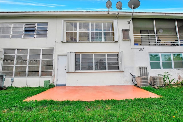 back of property with a patio, cooling unit, and a yard