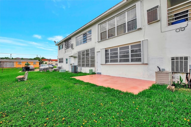 121 NE 204th St Unit 9, Miami Gardens, FL 33179 - back of house with stucco siding, a yard, cooling unit, and a patio