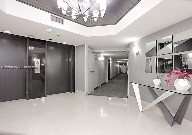 3300 NE 192nd St Unit 414, Aventura, FL 33180 - hallway with a chandelier and tile patterned flooring