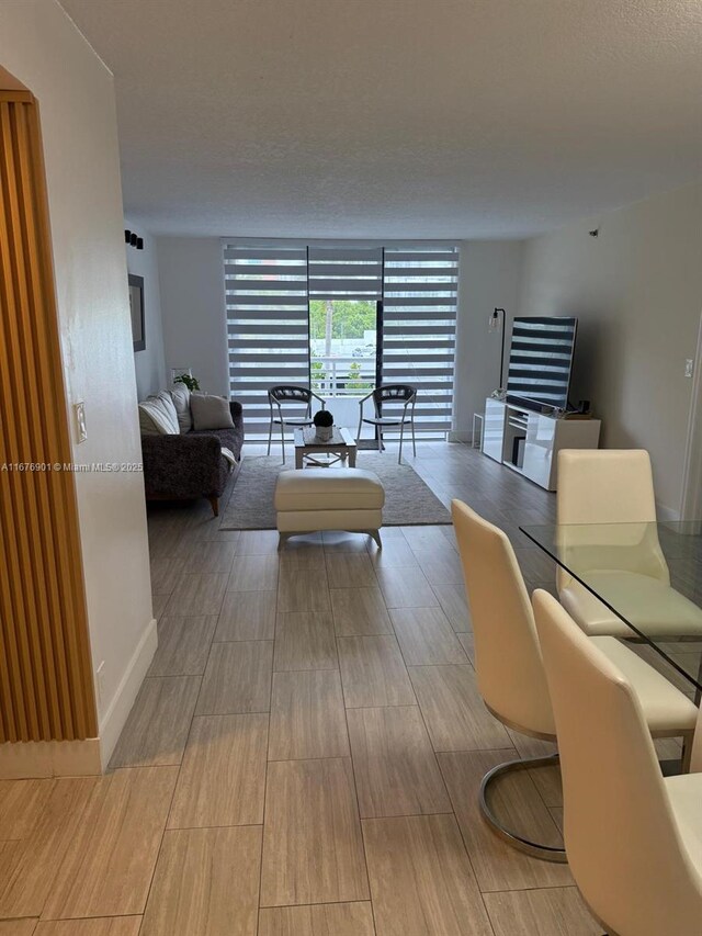 3300 NE 192nd St Unit 414, Aventura, FL 33180 - living room with wood finished floors and a wall of windows