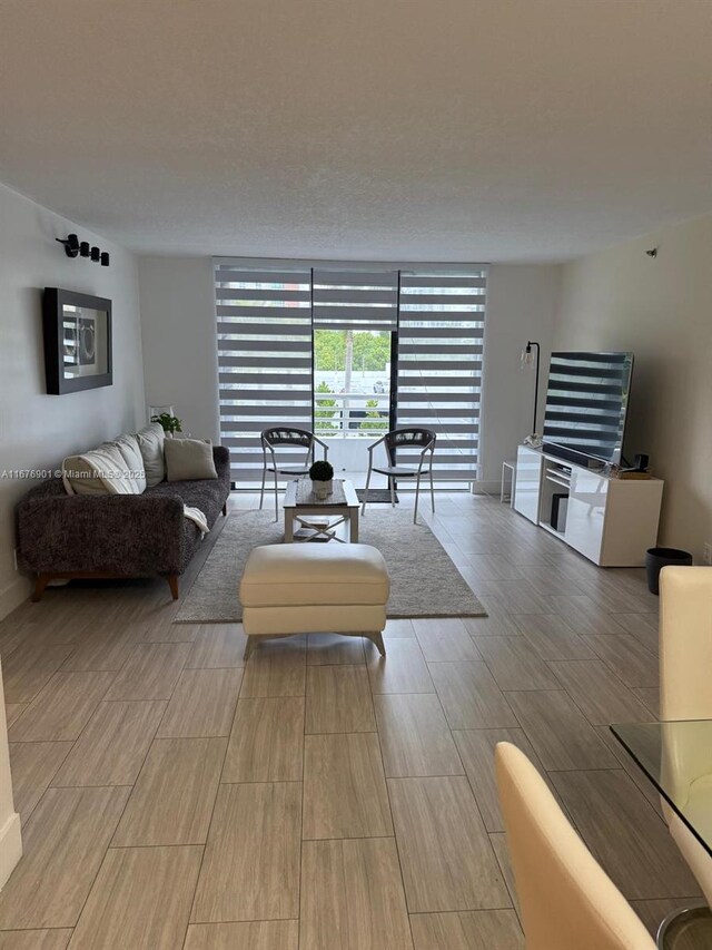 3300 NE 192nd St Unit 414, Aventura, FL 33180 - living room featuring floor to ceiling windows and wood tiled floors