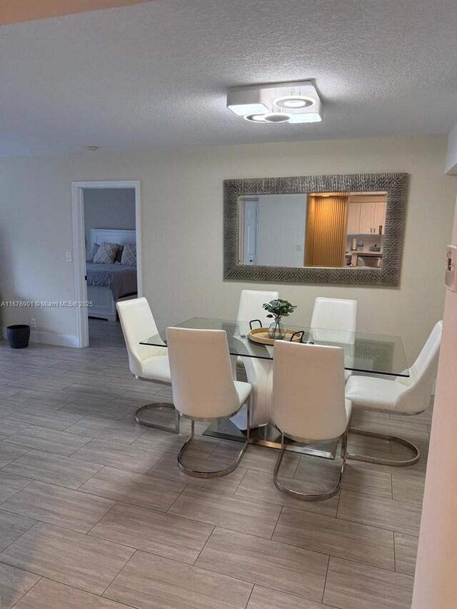 3300 NE 192nd St Unit 414, Aventura, FL 33180 - dining room with a textured ceiling and baseboards