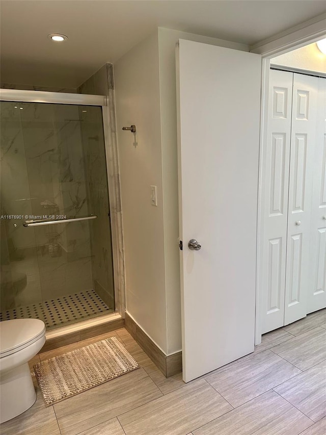 bathroom with toilet and an enclosed shower