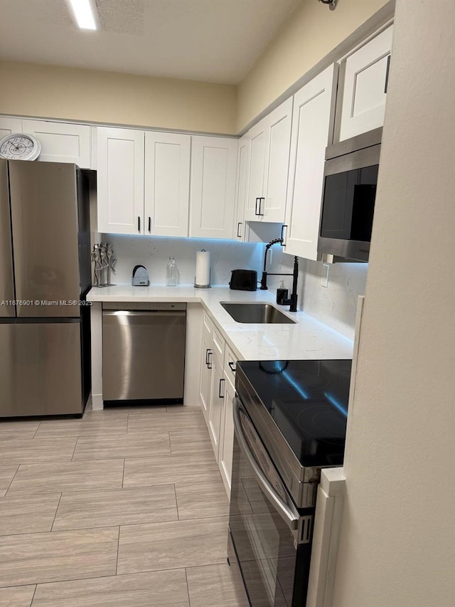 3300 NE 192nd St Unit 414, Aventura, FL 33180 - kitchen featuring stainless steel appliances, white cabinets, light countertops, and wood finish floors