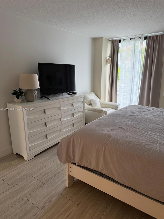3300 NE 192nd St Unit 414, Aventura, FL 33180 - bedroom with light wood-style floors and a textured ceiling
