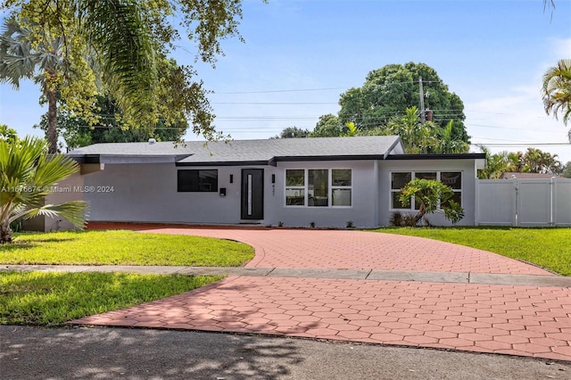 single story home featuring a front lawn