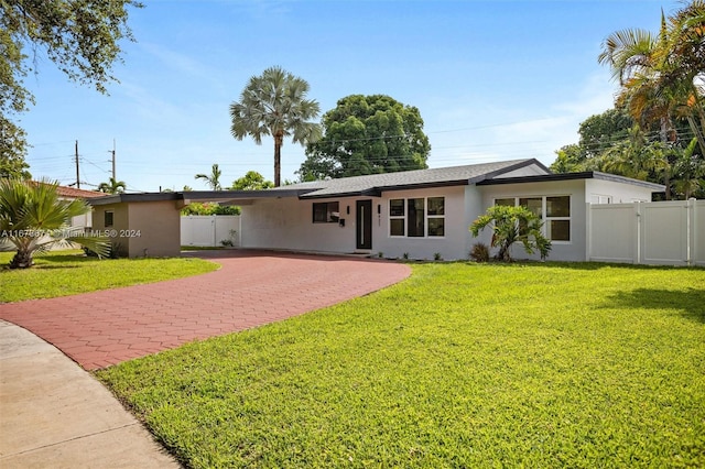 ranch-style home with a carport and a front lawn