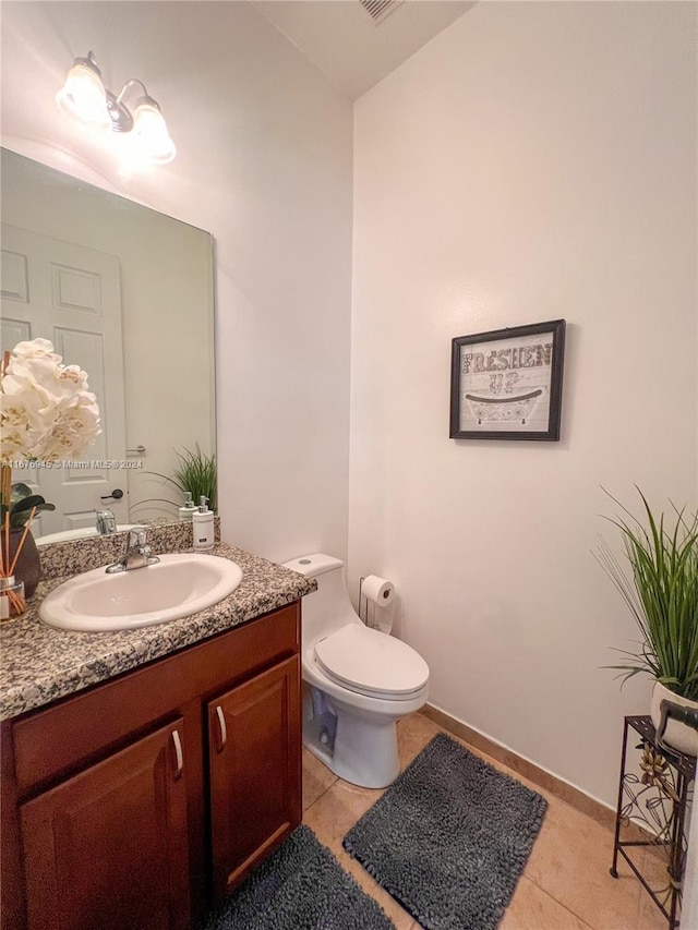 half bath with vanity, tile patterned floors, and toilet