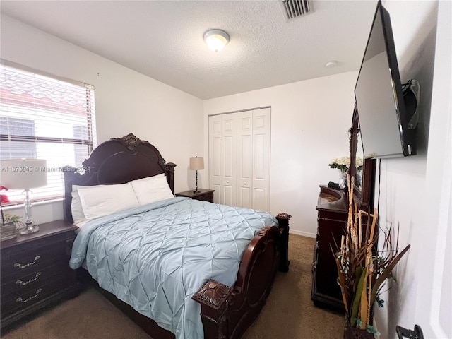 bedroom with carpet floors, visible vents, a closet, baseboards, and a textured ceiling