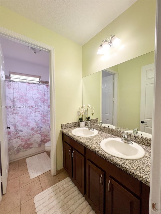 bathroom featuring a textured ceiling, walk in shower, toilet, vanity, and tile patterned flooring